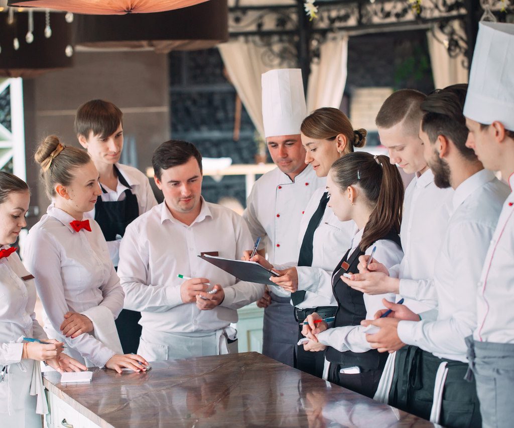 funcionários e chefe de restaurante reunidos para gestão de restaurantes na pandemia